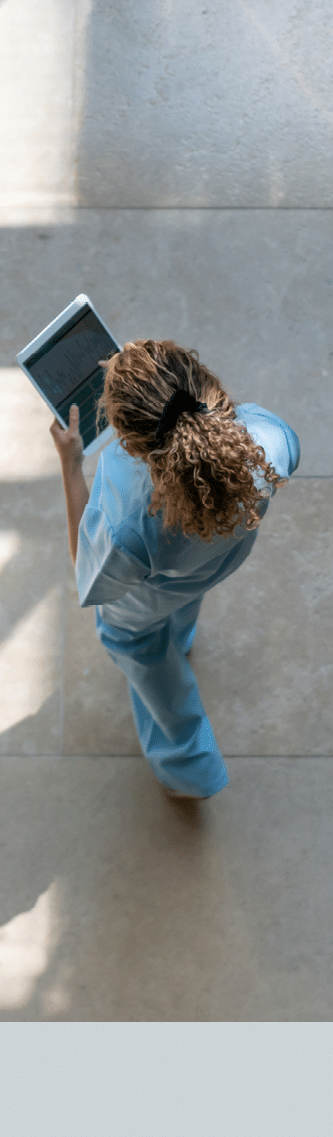 High angle view of nurse walking around hospital while looking at a medical chart on tablet  **DESIGN ON SCREEN WAS MADE FROM SCRATCH BY US**