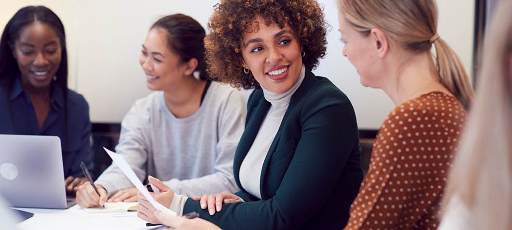 Group Of Businesswomen Collaborating In Creative Meeting Around Table In Modern Office